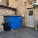 TuffBoxx commercial bins installed at restaurant loading dock showing heavy-duty blue steel construction with secure latches for wildlife-resistant waste storage